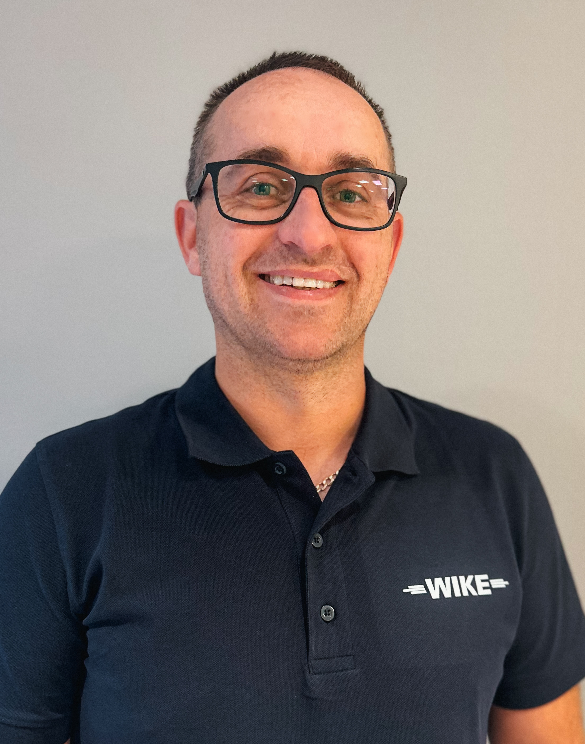 Nærbilde av gravemaskinskuffe som spruter jord.