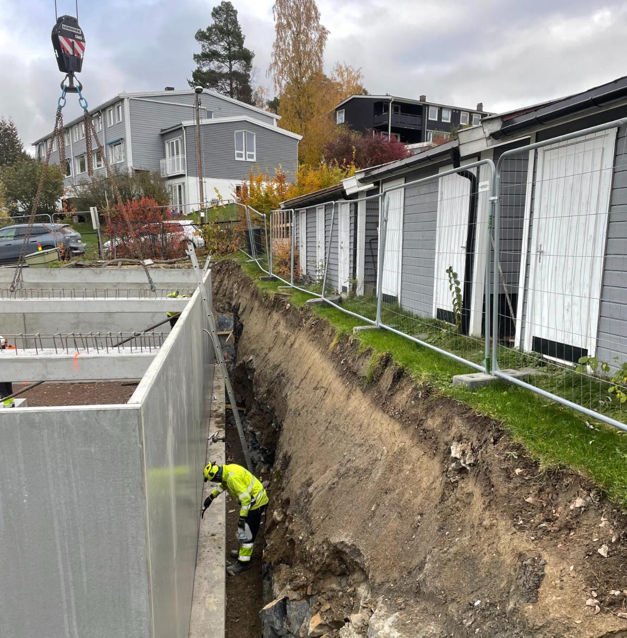 Bygningsarbeider jobber ved ny betongkonstruksjon i utgravd byggegrop